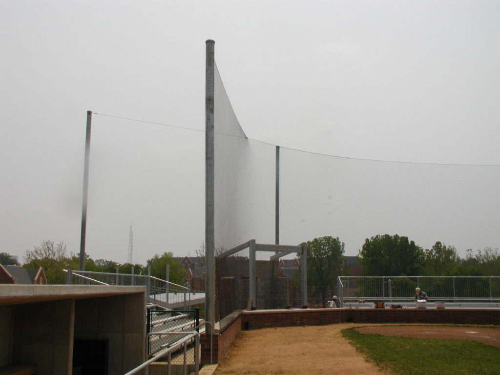 Sports fence installation surrounding an athletic field with durable fencing and safety barriers.
